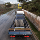 A screen from Forza Horizon 5 showing a car being hauled on a flatbed truck.